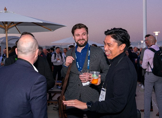 Attendees conversing with drinks at the beer garden happy hour